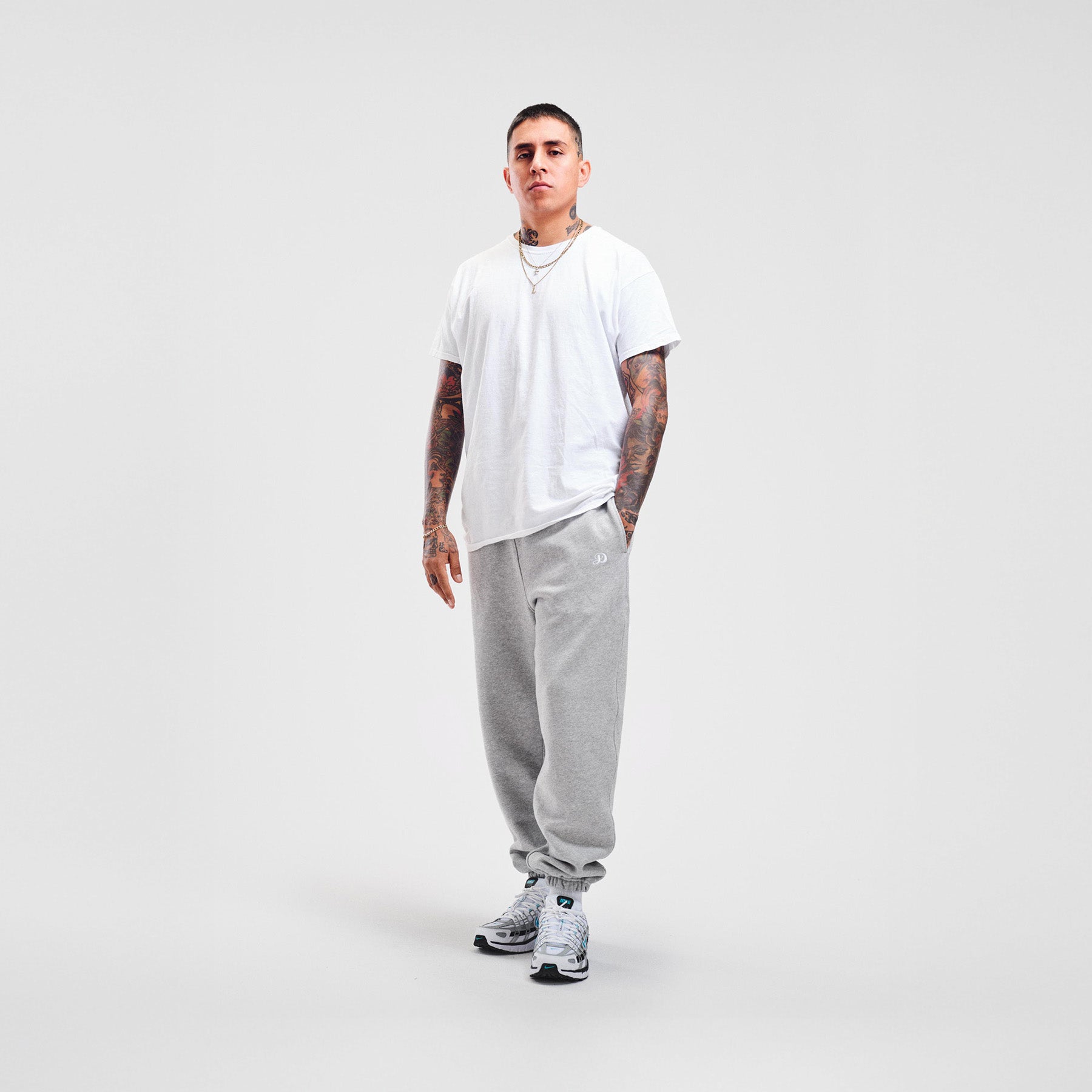 man model tattoos gray sweatpants nike sneakers high quality luxury streetwear new york city nyc damiano clothing